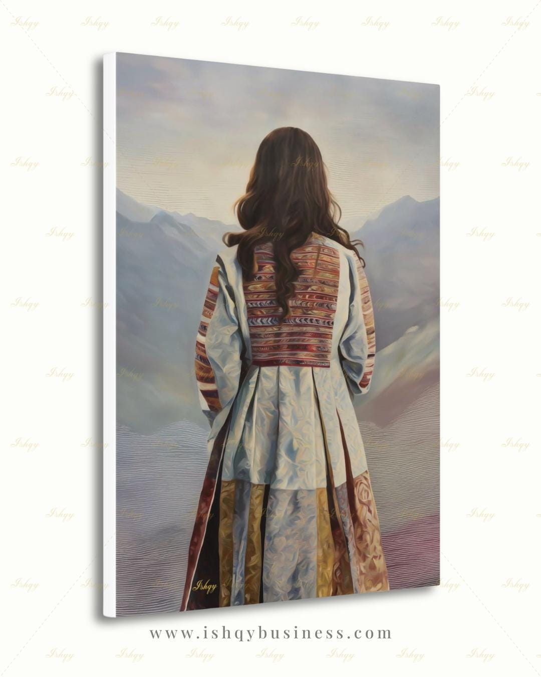 Back-view portrait of a woman with long dark wavy hair wearing a traditional Afghan embroidered dress with intricately paneled fabric in blue, rust, and earth tones, against a misty layered mountain landscape.