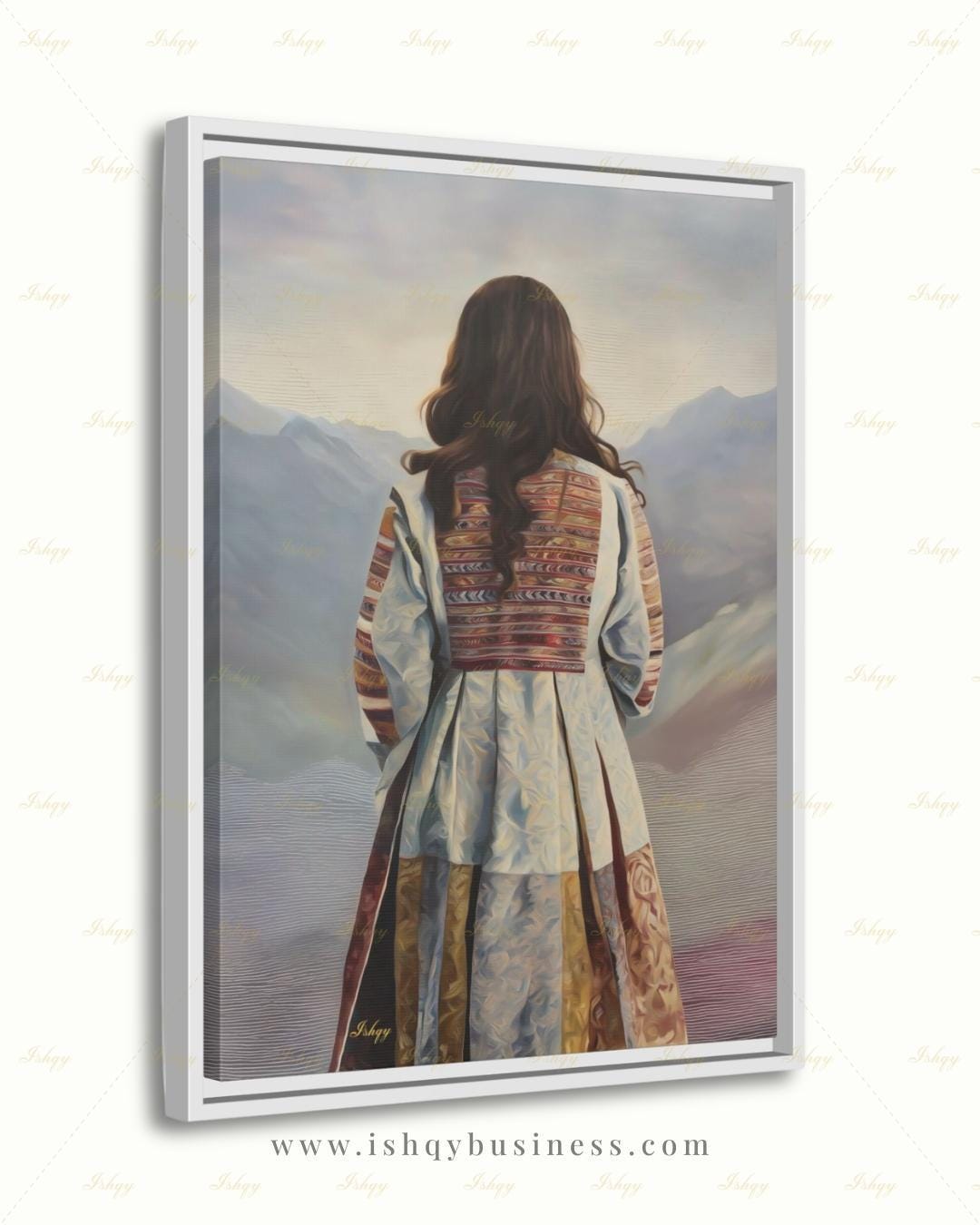Back-view portrait of a woman with long dark wavy hair wearing a traditional Afghan embroidered dress with intricately paneled fabric in blue, rust, and earth tones, against a misty layered mountain landscape.