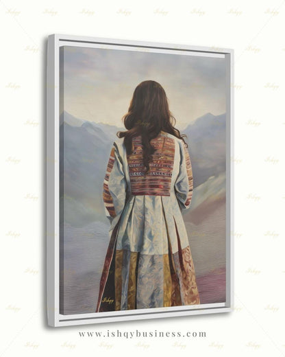 Back-view portrait of a woman with long dark wavy hair wearing a traditional Afghan embroidered dress with intricately paneled fabric in blue, rust, and earth tones, against a misty layered mountain landscape.